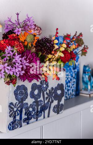 Fleurs coupées colorées en vase sur étagère sur l'île de Tinos en Grèce Banque D'Images