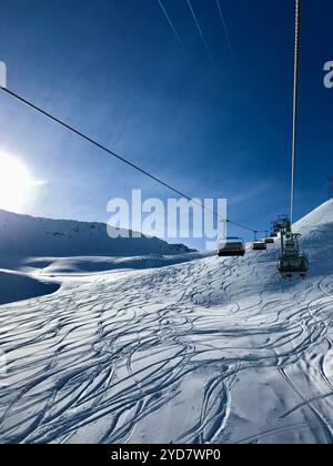 Remontée mécanique au-dessus des alpes suisses enneigées sous le soleil Banque D'Images