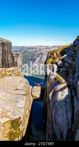 Une personne se tient sur le bord de la roche Kjeragbolten Pulpit en Norvège Banque D'Images