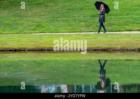 Glimmers in the Gloom : a Woman's graceful Dance with the Rain Banque D'Images