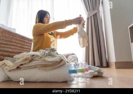 Femme asiatique enceinte se préparant pour la maternité préparer et planifier des vêtements pour bébé pour de nouveaux babyÂ de grossesse pac Banque D'Images