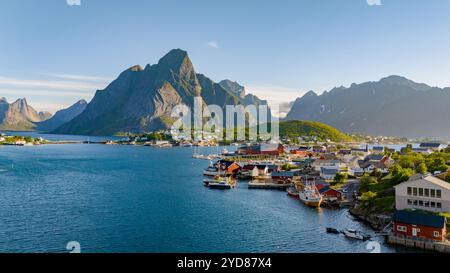 Une vue pittoresque sur un charmant village côtier norvégien, entouré de montagnes majestueuses et d'une mer bleue tranquille. Reine, Lofoten, Norvège Banque D'Images