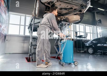 Mécanicien de voiture Remplacement de l'huile dans le moteur. Atelier d'entretien automobile Banque D'Images