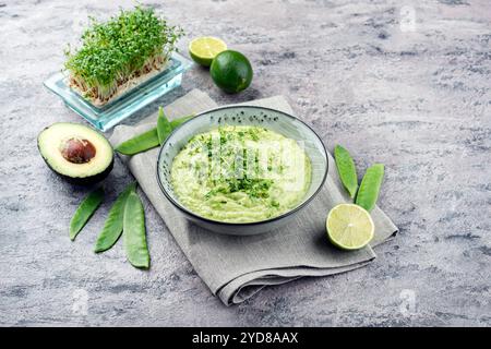 Trempette printanière exotique traditionnelle avec avocat et légumes rôtis servis en gros plan dans un bol au design nordique Banque D'Images