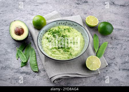 Trempette printanière exotique traditionnelle avec avocat et légumes rôtis servis en gros plan dans un bol au design nordique Banque D'Images