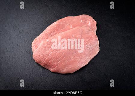 Filets d'escalope de poulet crus traditionnels offerts en gros plan sur un tableau noir avec espace de copie Banque D'Images