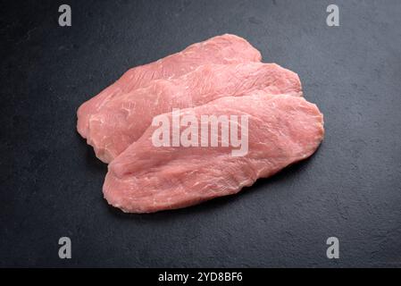 Filets d'escalope de poulet crus traditionnels offerts en gros plan sur un tableau noir avec espace de copie Banque D'Images