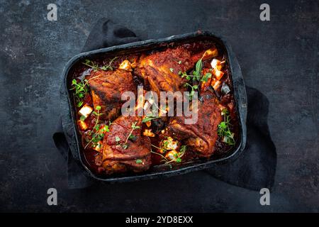 Jarret d'agneau braisé traditionnel cuit lentement avec aubergines et fromage feta grec servi comme vue de dessus sur une casserole rustique avec c Banque D'Images