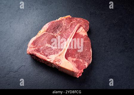 Steak de bœuf chianina vieilli cru et sec offert en gros plan sur une vieille planche rustique Banque D'Images