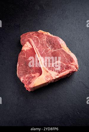 Steak de bœuf chianina vieilli cru et sec offert en gros plan sur une vieille planche rustique Banque D'Images