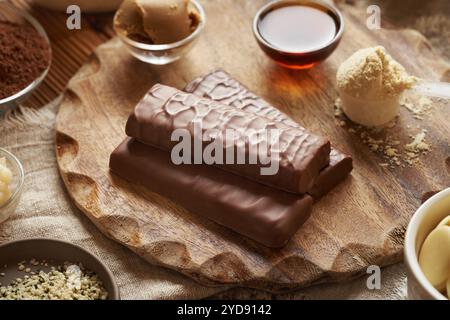 Poudre de protéines de lactosérum, sirop d'érable, beurre d'arachide et de cacao, cacao brut et graines de chanvre - ingrédients pour des barres de chocolat protéinées saines Banque D'Images