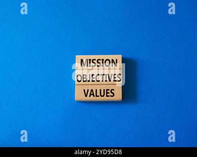 Symbole des valeurs des objectifs de mission. Mots conceptuels objectifs de mission valeurs sur blocs de bois. Beau fond bleu. Objectifs commerciaux et de mission Banque D'Images