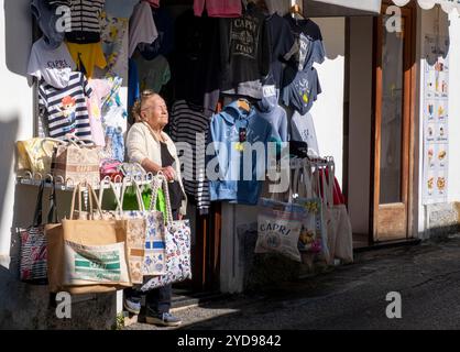 Magasinier se prélassant au soleil devant sa boutique, Anacapri, île de Capri, Campanie, Italie. Banque D'Images