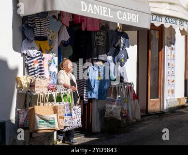 Magasinier se prélassant au soleil devant sa boutique, Anacapri, île de Capri, Campanie, Italie. Banque D'Images