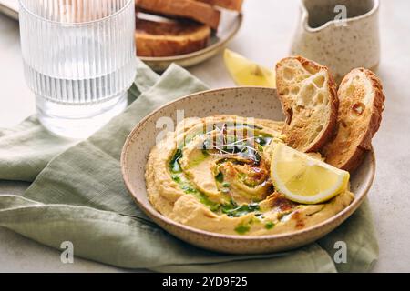 Délicieux houmous maison avec citron, paprika, huile d'olive et microgreens. Plat végétarien du moyen-Orient Banque D'Images