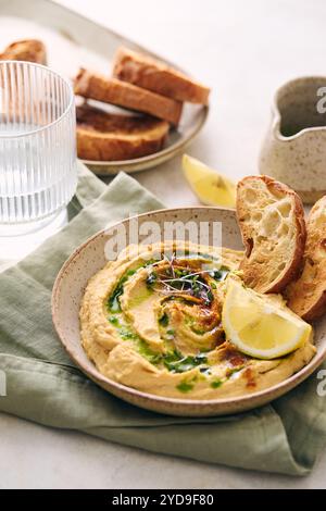 Délicieux houmous maison avec citron, paprika, huile d'olive et microgreens. Plat végétarien du moyen-Orient Banque D'Images