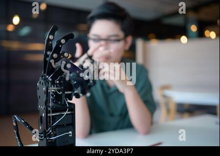 Les progrès de la technologie ont contribué à alléger les charges humaines. Robot à commande manuelle C'est un autre type de travail que assis Banque D'Images