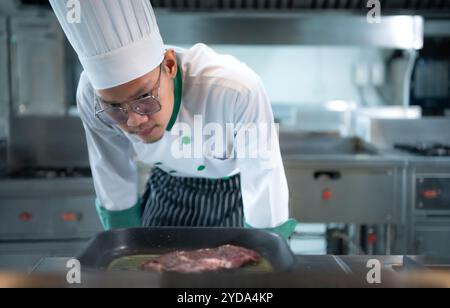 Chef professionnel qui se spécialise dans les viandes fines le steak qui est servi au client est incontestablement délicieux. Banque D'Images