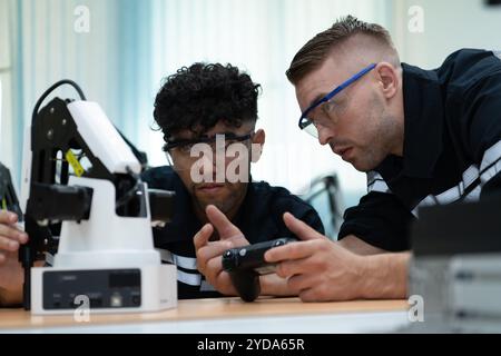 Le professeur de technologie de main robotique enseigne aux nouveaux élèves comment construire des mains robotiques pour une variété d'appl industrielles Banque D'Images