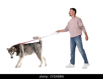 Homme heureux promenant son chien sur fond blanc Banque D'Images