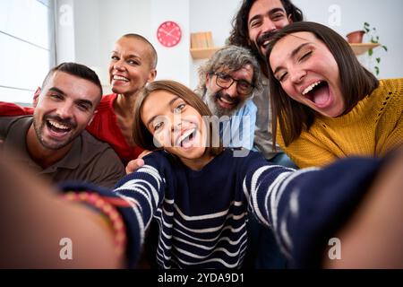 Joyeuse famille caucasienne prenant une photo selfie avec des expressions drôles à la maison. Relations positives. Banque D'Images