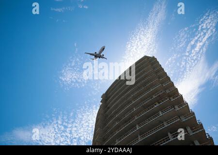 Avion volant au-dessus d'un bâtiment en ville, vue en angle bas Banque D'Images