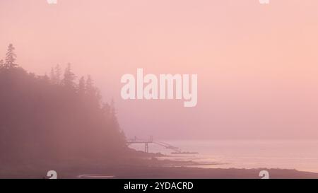 Coucher de soleil rose reflet avec voilier et jetée de pêche rustique à Stonington Maine sur Deer Isle Banque D'Images