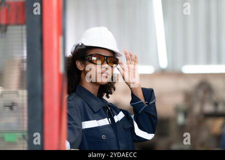 Portrait d'une jeune femme ingénieur dans l'industrie du robot de soudage, posée comme un top model. Banque D'Images