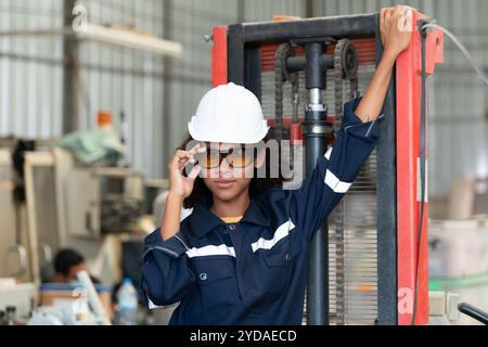 Portrait d'une jeune femme ingénieur dans l'industrie du robot de soudage, posée comme un top model. Banque D'Images