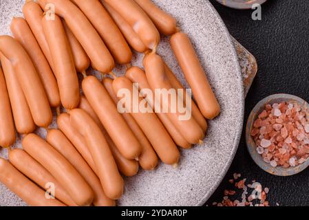 Délicieuses saucisses végétariennes ou végétaliennes avec du sel, des épices et des herbes sur un fond de béton foncé Banque D'Images