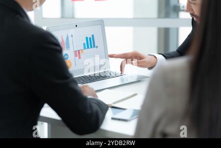 Un groupe de jeunes entrepreneurs asiatiques. La haute direction se réunit pour examiner les données d'investissement boursier de l'équipe dans une salle de réunion Banque D'Images