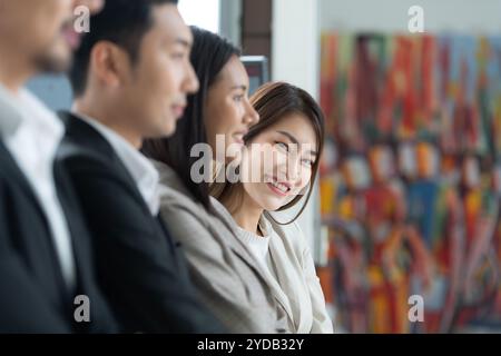 Jeune femme asiatique première année a rejoint le groupe de jeunes entrepreneurs avec trois seniors dans l'équipe. Banque D'Images