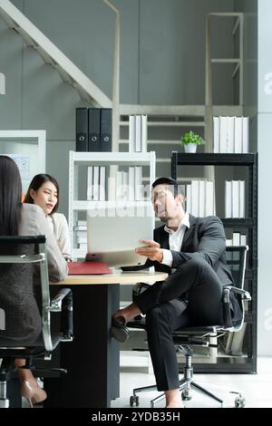 Un groupe de jeunes entrepreneurs asiatiques. La haute direction se réunit pour examiner les données d'investissement boursier de l'équipe dans une salle de réunion Banque D'Images