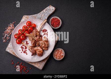 Délicieuse viande juteuse sur l'os ou le carré d'agneau ou de veau grillé avec du sel, des épices et des herbes Banque D'Images