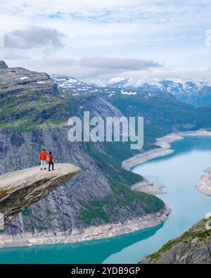 Couple admire Norwegian Fjord View Trolltunga, Norvège Banque D'Images