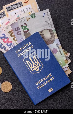 Passeport ukrainien biométrique, billets d'avion et argent sur fond de béton foncé. Contexte conceptuel sur le thème du tourisme et des voyages Banque D'Images