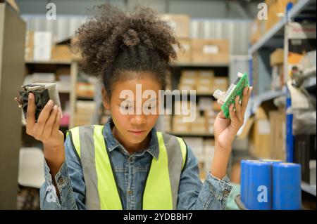 Travailleuse d'entrepôt comptant des articles dans un entrepôt industriel sur le plancher de mezzanine de l'usine. ce qui est un stockage pour les petits Banque D'Images