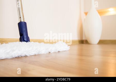 Plancher en bois avec balai blanc, concept de service de nettoyage Banque D'Images
