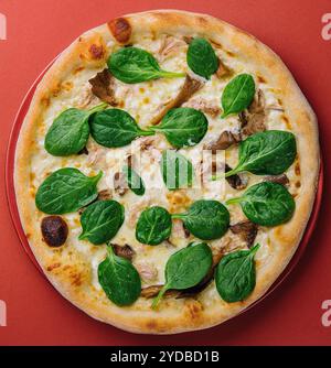 Pizza aux champignons chauds avec basilic sur assiette rouge Banque D'Images