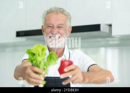 Grand-père prépare le petit déjeuner et prépare la nourriture pour les petits-enfants dans la cuisine de la maison. Banque D'Images