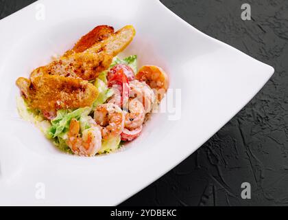 Salade de laitue avec sauce César, crevettes tigrées, fromage et chapelure Banque D'Images