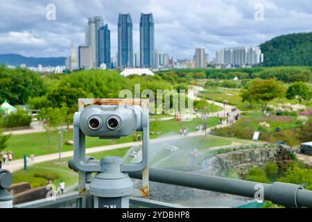 Ulsan, Corée du Sud - 5 octobre 2024 : une paire de jumelles offre une vue sur le jardin national de la rivière Taehwa, avec des sentiers pédestres, de la verdure et la dista Banque D'Images