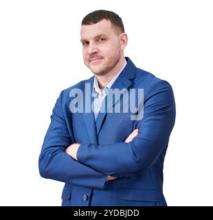 Jeune homme d'affaires prospère avec les bras croisés portant un costume bleu avec un beau sourire authentique posant sur fond blanc esprit Banque D'Images
