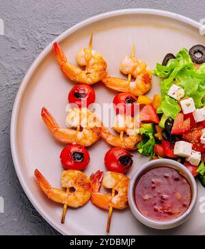 Brochettes de crevettes gourmandes avec salade verte et sauce Banque D'Images