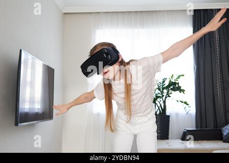 Adolescente portant casque de lunettes de réalité virtuelle et jouant, boîte vr. technologie, nouvelle génération, concept de progrès. Fille essayez Banque D'Images