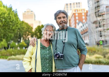 Portrait de couple senior de touristes debout embrassant de l'épaule dans la ville Banque D'Images