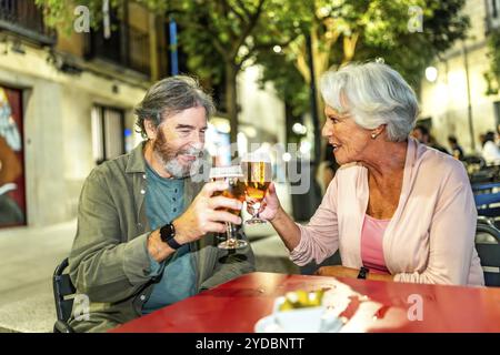 Couple senior toast dans un bar trottoir dans la ville de Madrid Banque D'Images