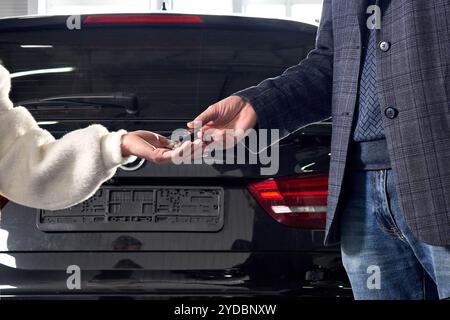 Un mécanicien donne les clés de la voiture au client après l'entretien Banque D'Images