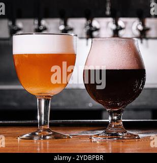 Verres de bière non filtrés et foncés sur la table dans l'intérieur du pub à la lumière du jour Banque D'Images