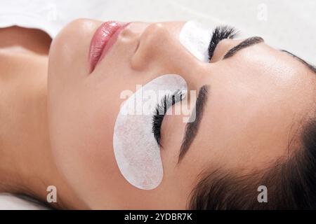 Belle femme avec de longues laisses dans un salon de beauté. Procédure d'extension des cils Banque D'Images